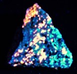 Sodalite syenite, Red Hill, Morltonborough, NH, FOV=2.5 in., unfiltered LWUV 365nm.JPG